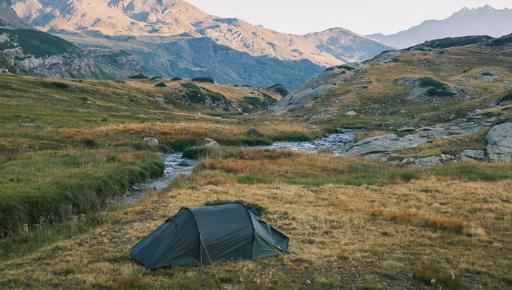 groene tent bij zonsopgang in de bergen